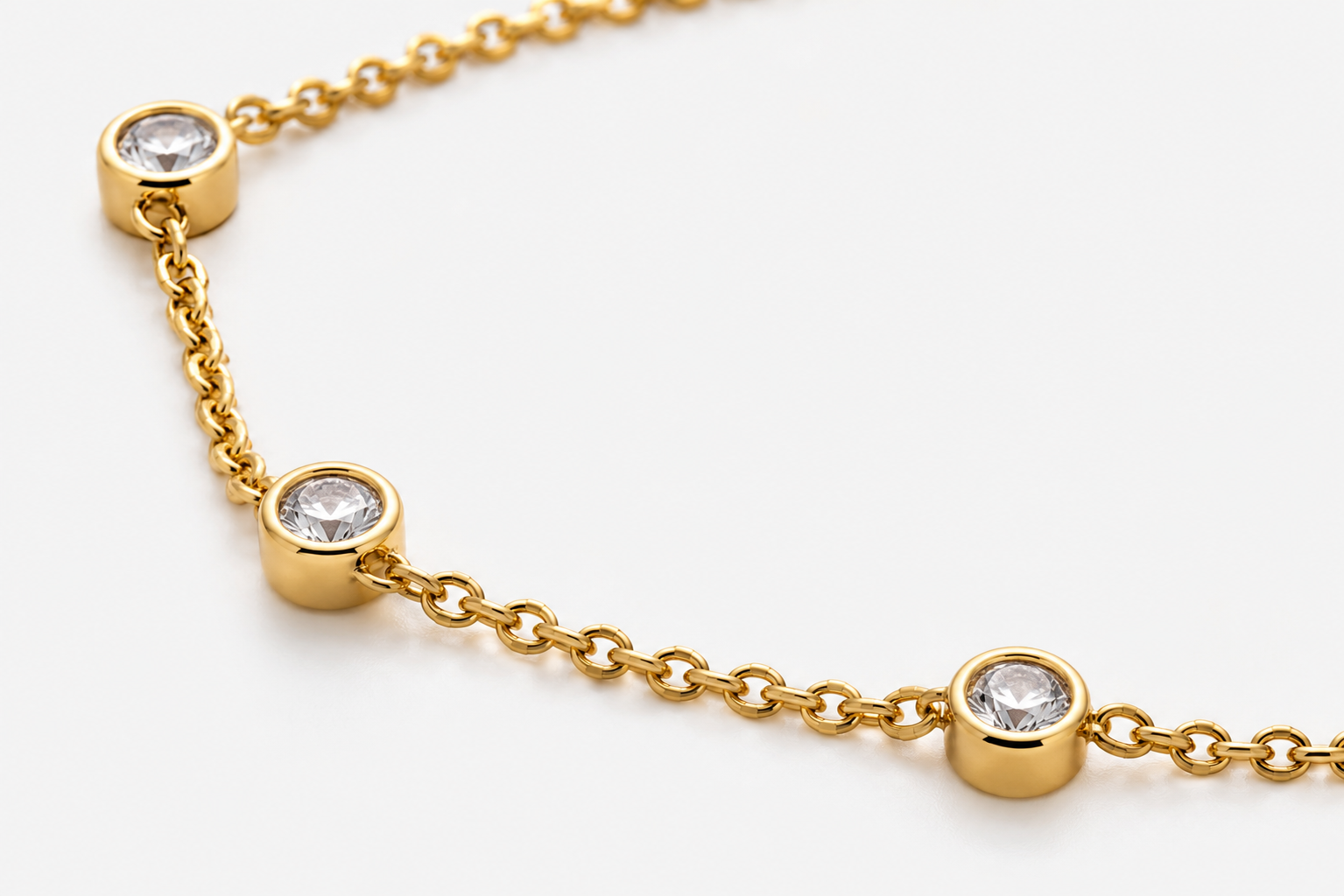 Close-up of Sélène bezel-set round diamonds on a yellow gold chain
