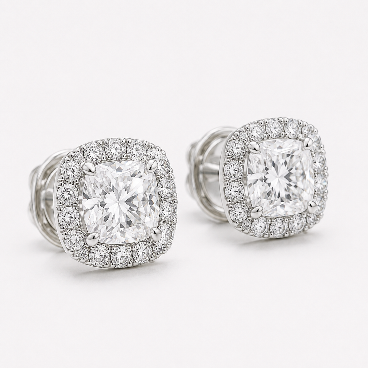 Close-up of cushion-cut natural diamond stud with round diamond halo in white gold
