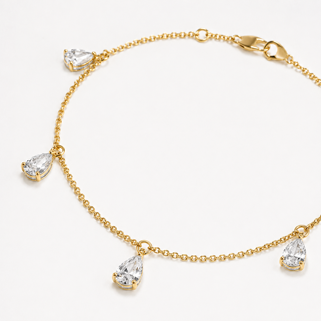 Close-up of pear-cut lab-grown diamond drops on 14K yellow gold bracelet

