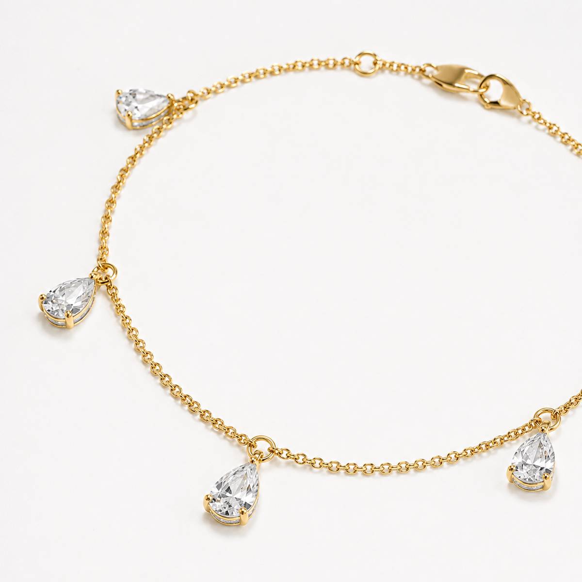 Close-up of pear-cut lab-grown diamond drops on 14K yellow gold bracelet
